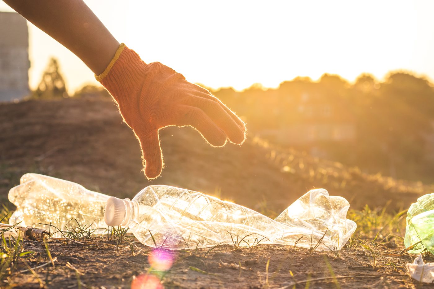 A Wilclean worker collecting a plastic bottle for recycling